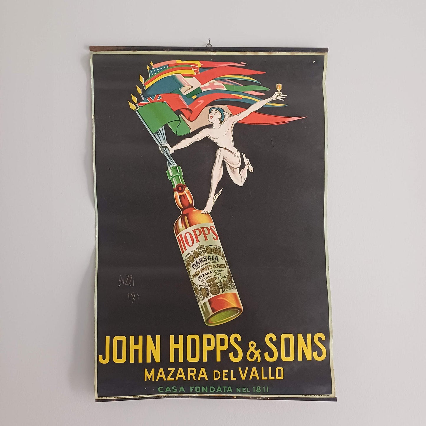 Affiche ancienne John Hopps & Sons de 1923 avec illustration colorée d’une bouteille de Marsala et personnage ailé, sous réglettes métalliques.