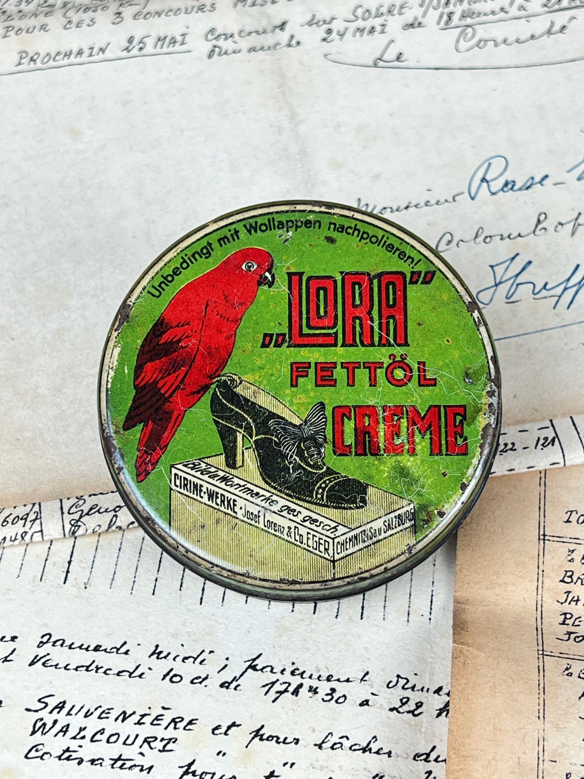 Ancienne boîte de cirage publicitaire en métal de la marque Lora, objet de collection en fer blanc lithographié d'époque vintage.