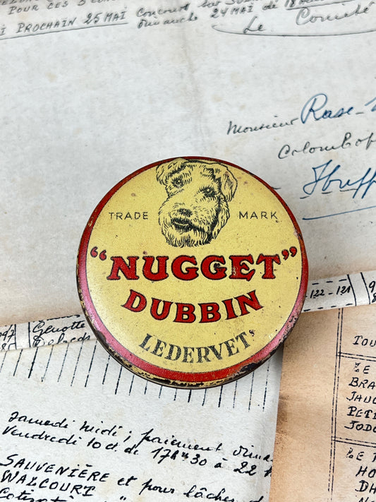 Ancienne boîte de cirage publicitaire en métal de la marque Nugget Dubbin, objet de collection en fer blanc lithographié d'époque vintage.