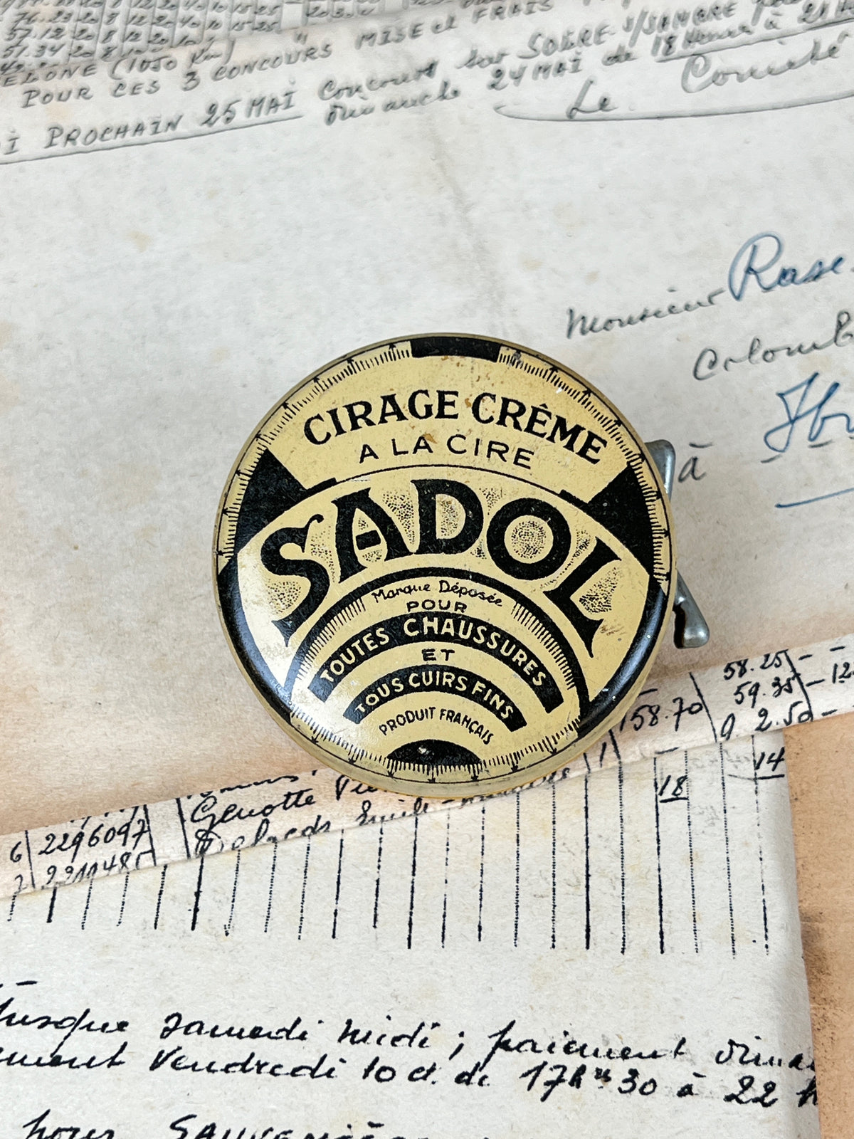 Ancienne boîte de cirage publicitaire en métal de la marque Sadol, objet de collection en fer blanc lithographié d'époque vintage.