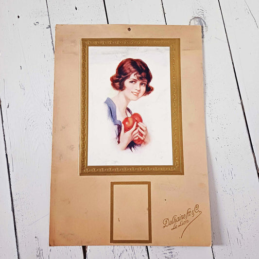 Ancien carton publicitaire Delhaize illustré d’une jeune femme portant des pommes, lithographie vintage Belgique.