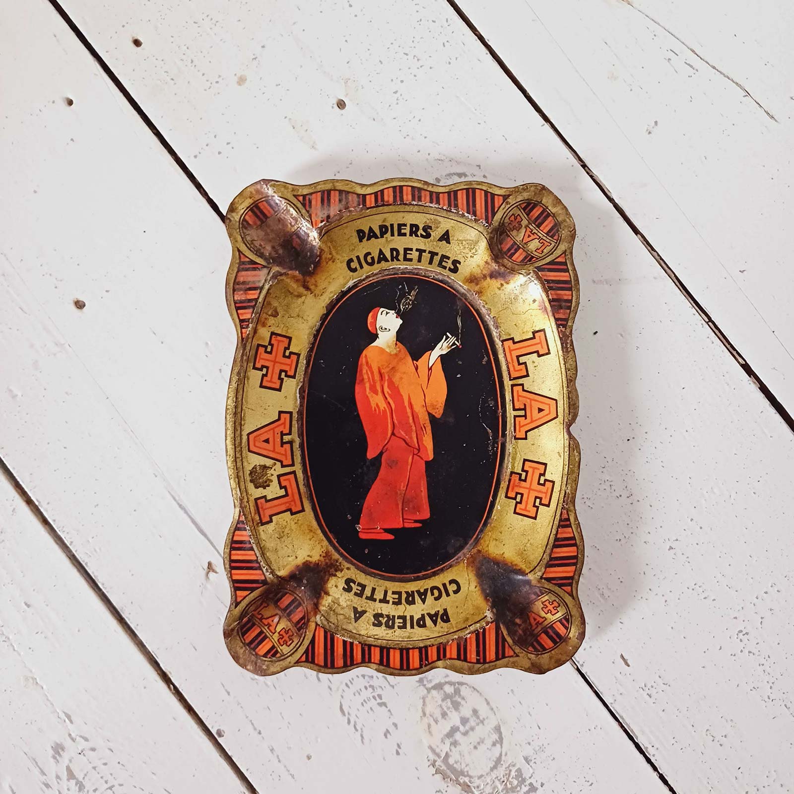 Cendrier ancien Rizla en tôle lithographiée, modèle LA+, visuel signé J. Spring, circa 1920.