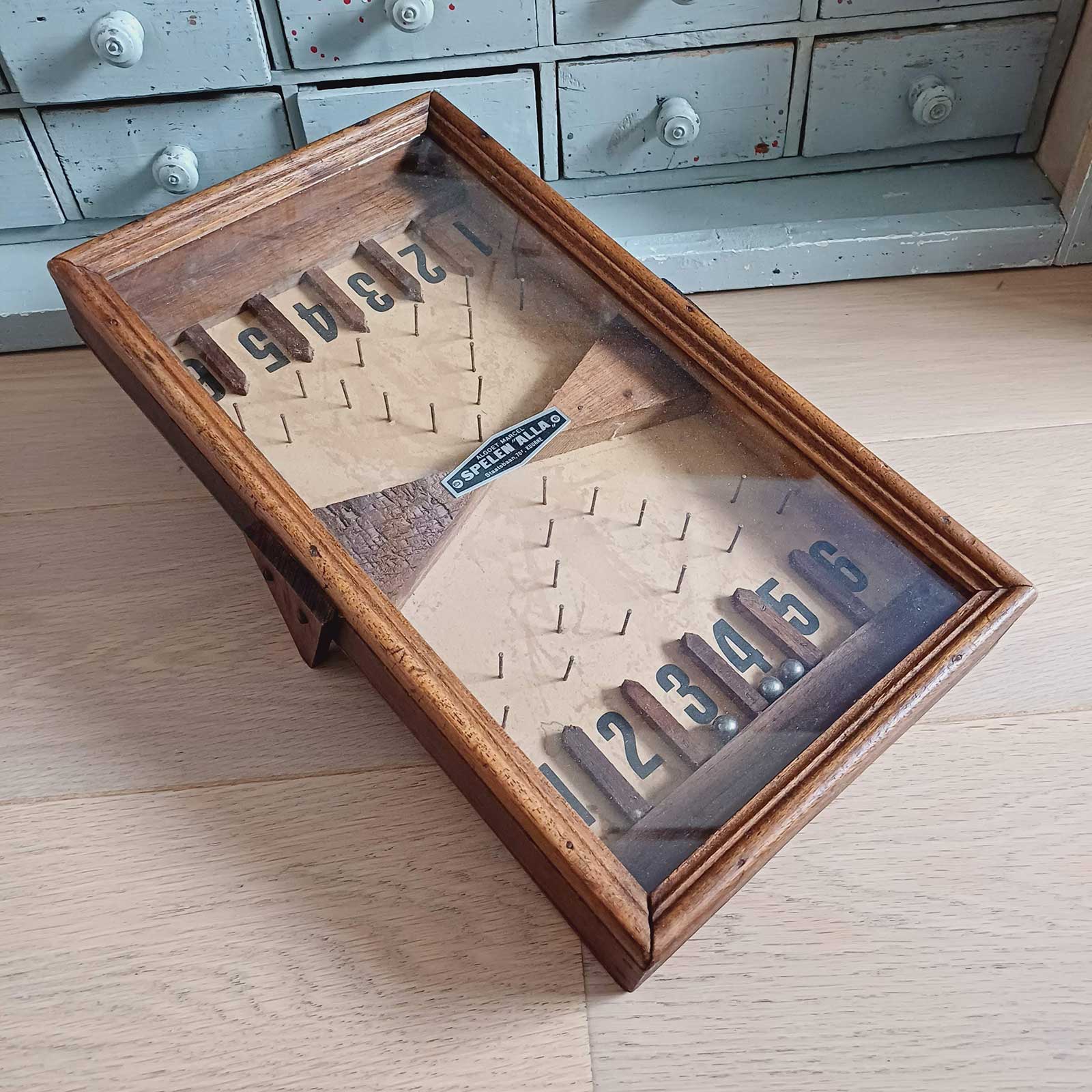 Ancien jeu de bagatelle de bistrot en bois, marque Alla à Kuurne, format 21 x 35,5 x 7,5 cm, en très bon état et fonctionnel.