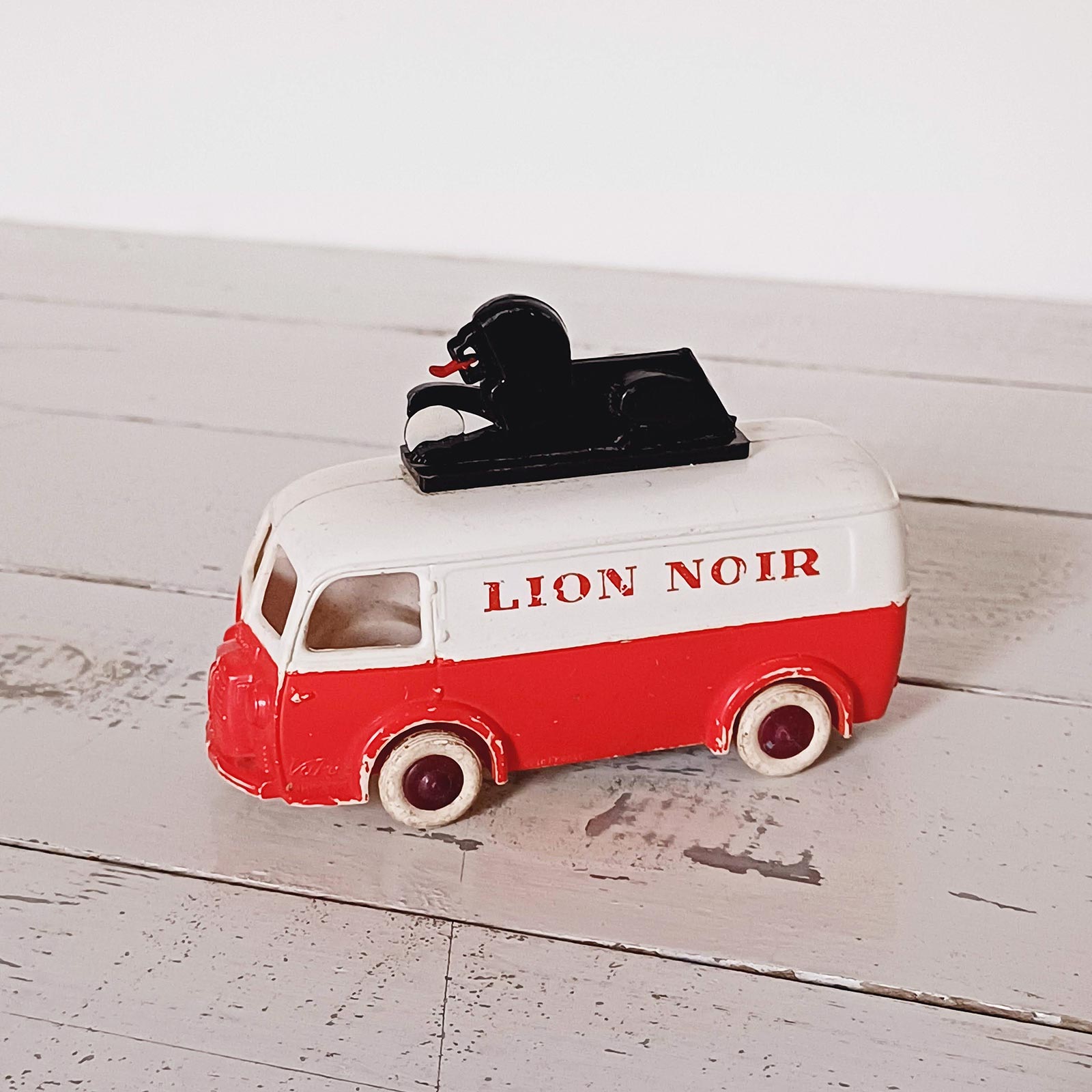 Jouet ancien Peugeot D3A à friction fabriqué par Bourbon, décoré Lion Noir, en plastique avec patine du temps.