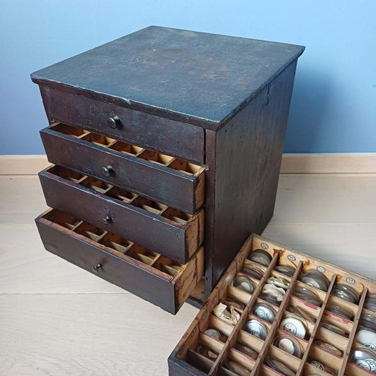 Ancienne layette d’horloger pour le rangement des verres de montres, meuble de métier vintage.