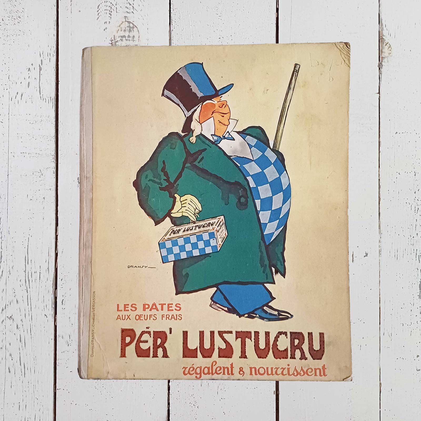 Protège-cahier publicitaire ancien Per' Lustucru en carton épais avec dos toilé, format 23 x 28 cm, illustration de Dransy avec traces du temps.