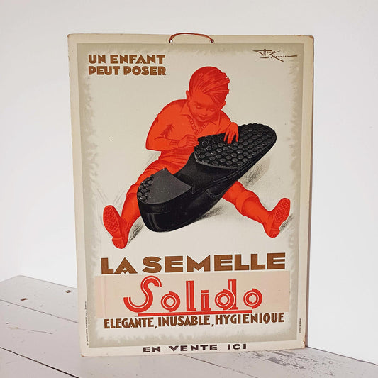 Publicité cartonnée vintage pour les semelles Solido, lithographiée par Henry Le Monnier, format 27 x 37 cm, en très bon état avec légères traces du temps.