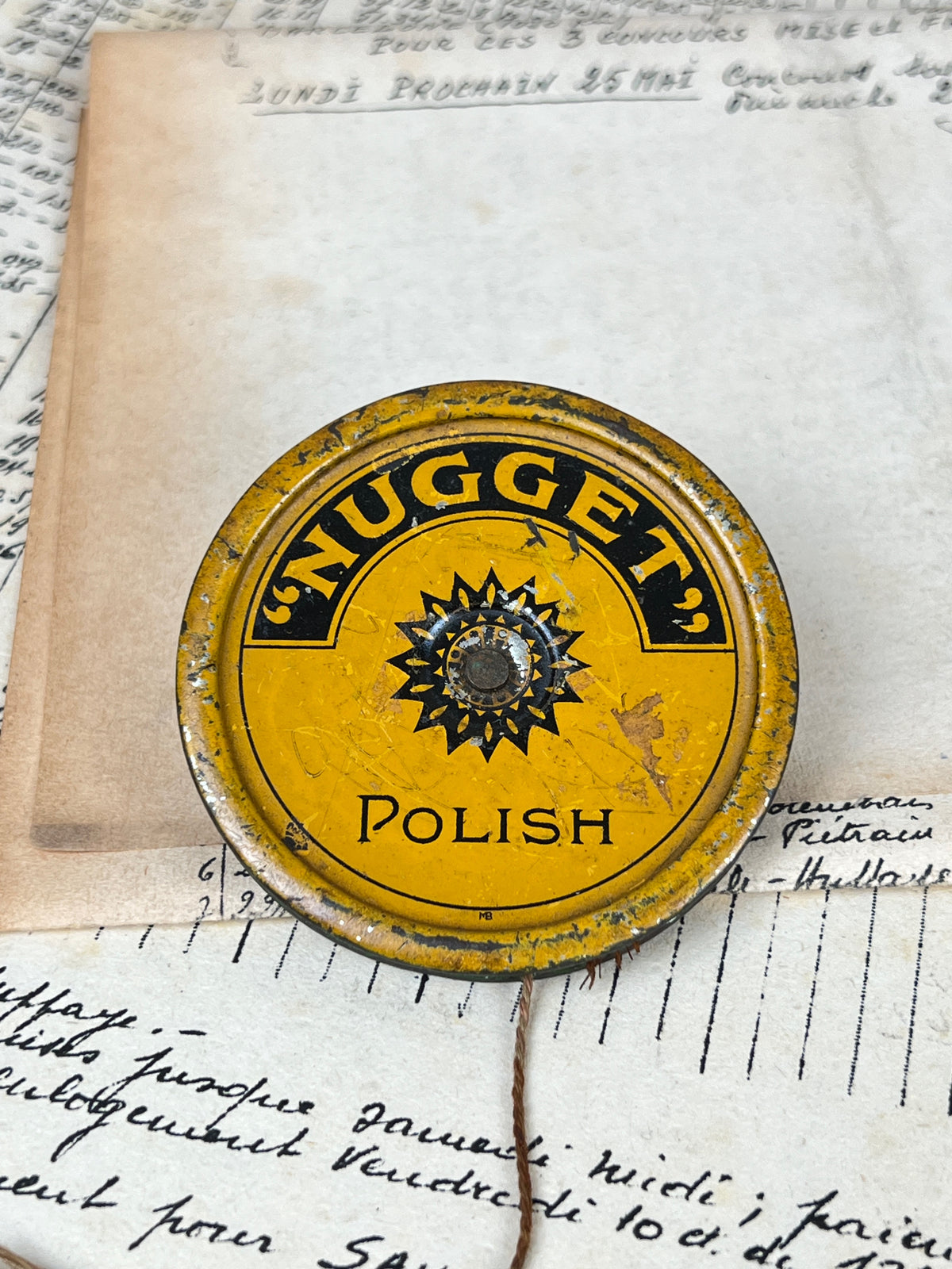 Ancien et rare yoyo publicitaire en métal lithographié jaune et noir de la marque de cirage Nugget Polish, jouet de collection vintage.