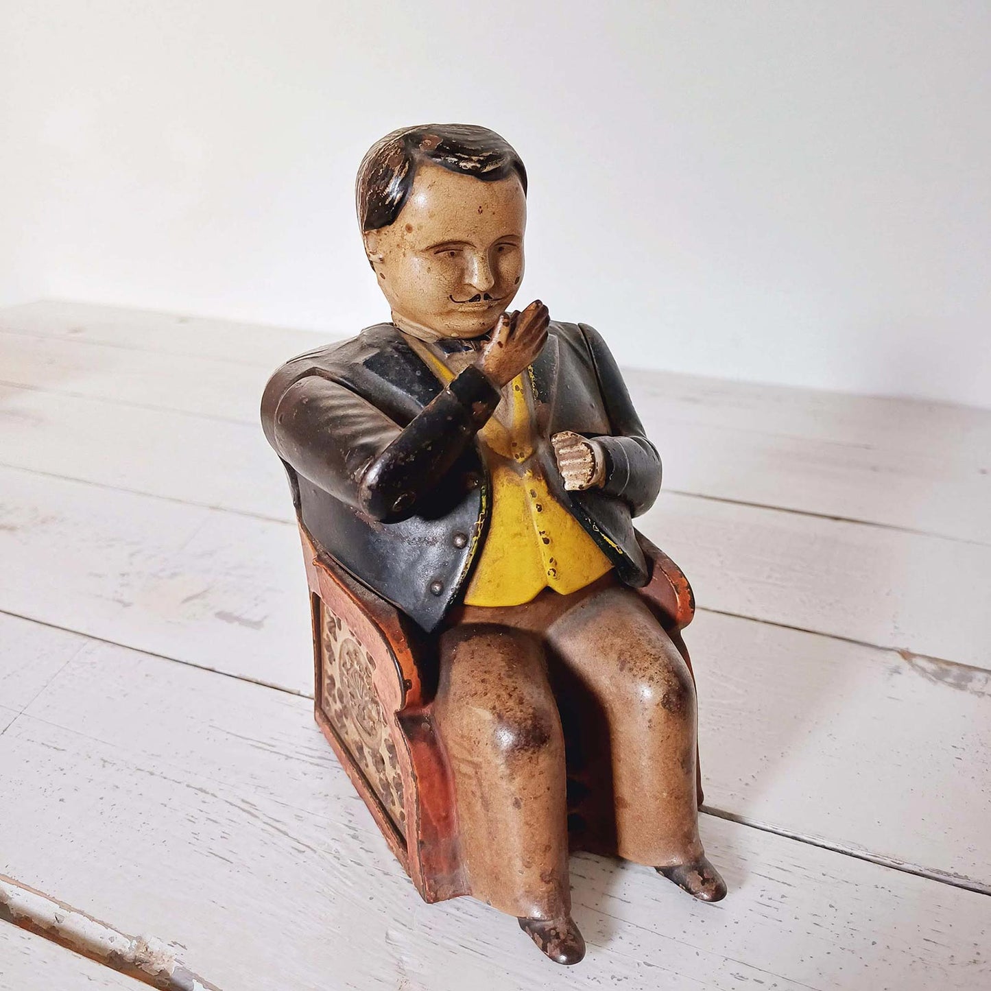 Tirelire mécanique ancienne Tammany Bank en tôle peinte représentant un homme assis, modèle américain breveté en 1873.